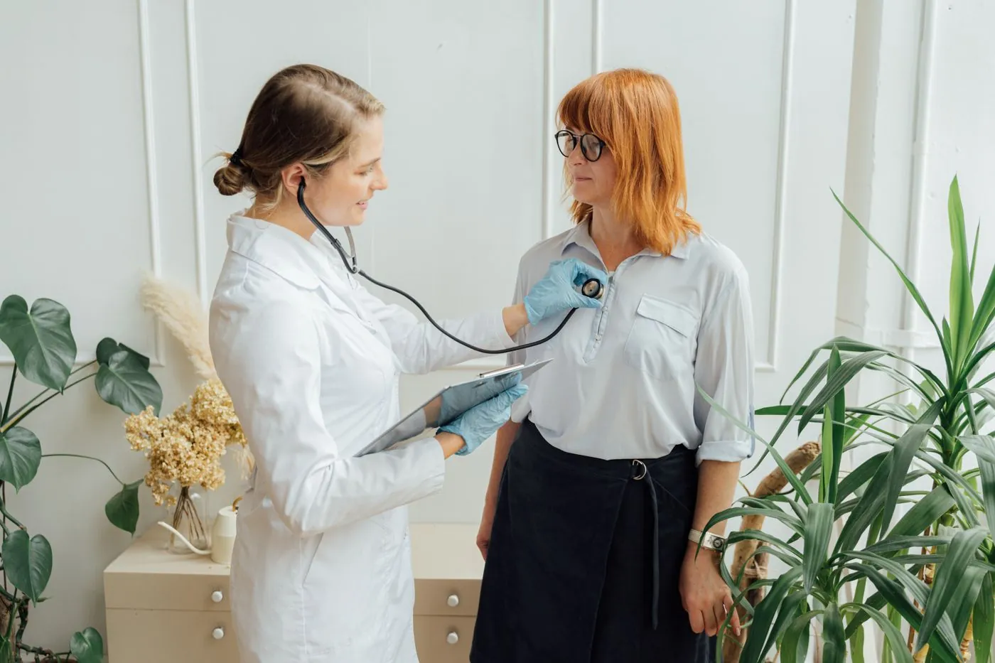 A doctor listening to a patient in a bright consulting room